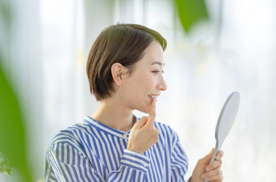 鏡で歯を見ている女性